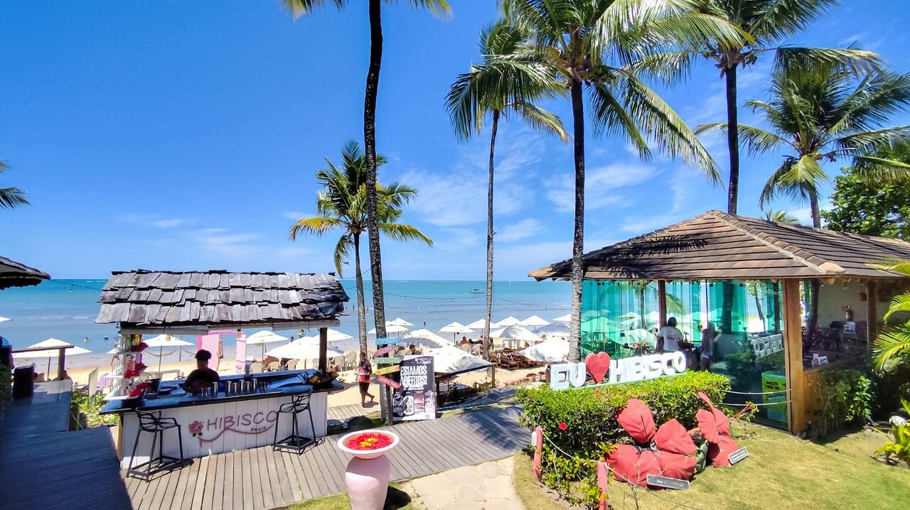 Vista panorâmica do Hibisco Praia com coqueiros, bar e mar da Praia do Mutá
